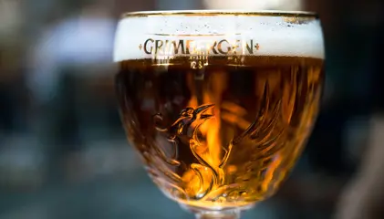 A glass of Grimbergen beer with a prominent head.