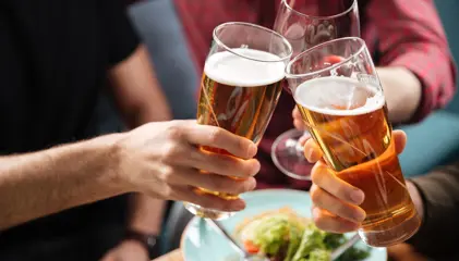 A group of people toasting with glasses of beer.