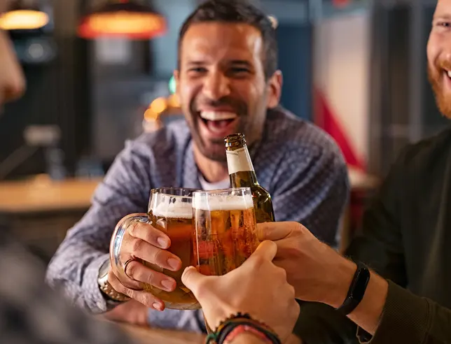 A group of people toasting with glasses of beer.