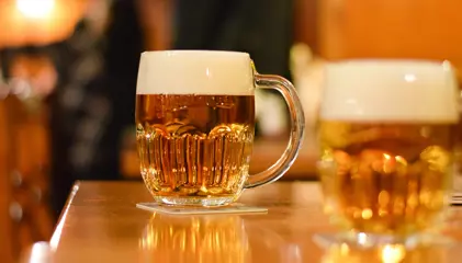 A mug of pilsner beer prominently displayed on a table.