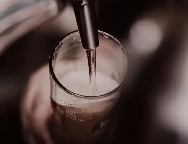 Beer being poured from a tap into a glass.